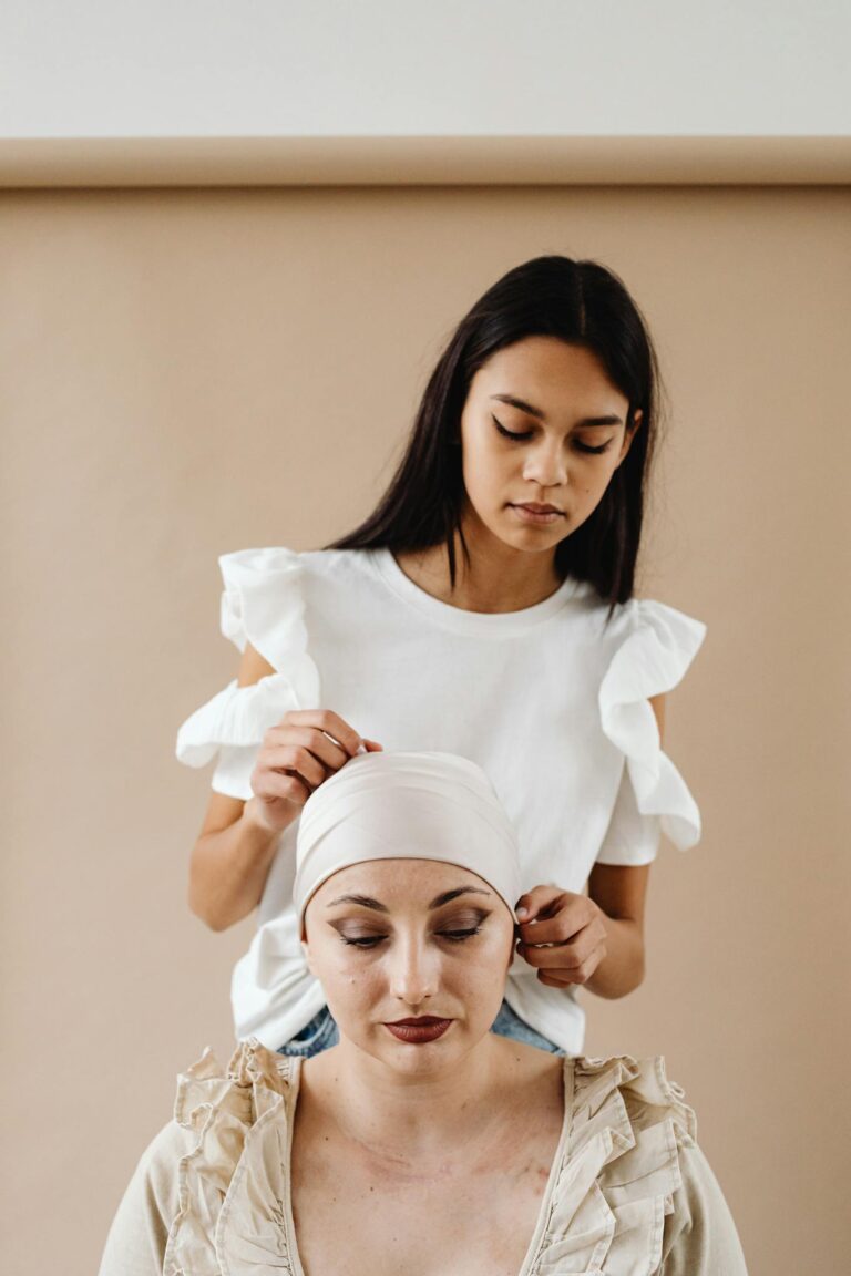 Asian woman supporting cancer patient with headscarf, showing friendship and care.